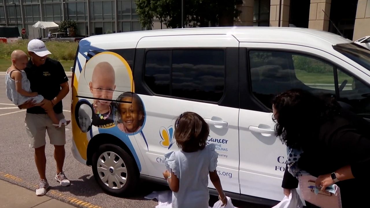 The Coxe family inspects the new service van for the Children’s Cancer Partners of the Carolinas. The van features a photo of Perry Coxe.
